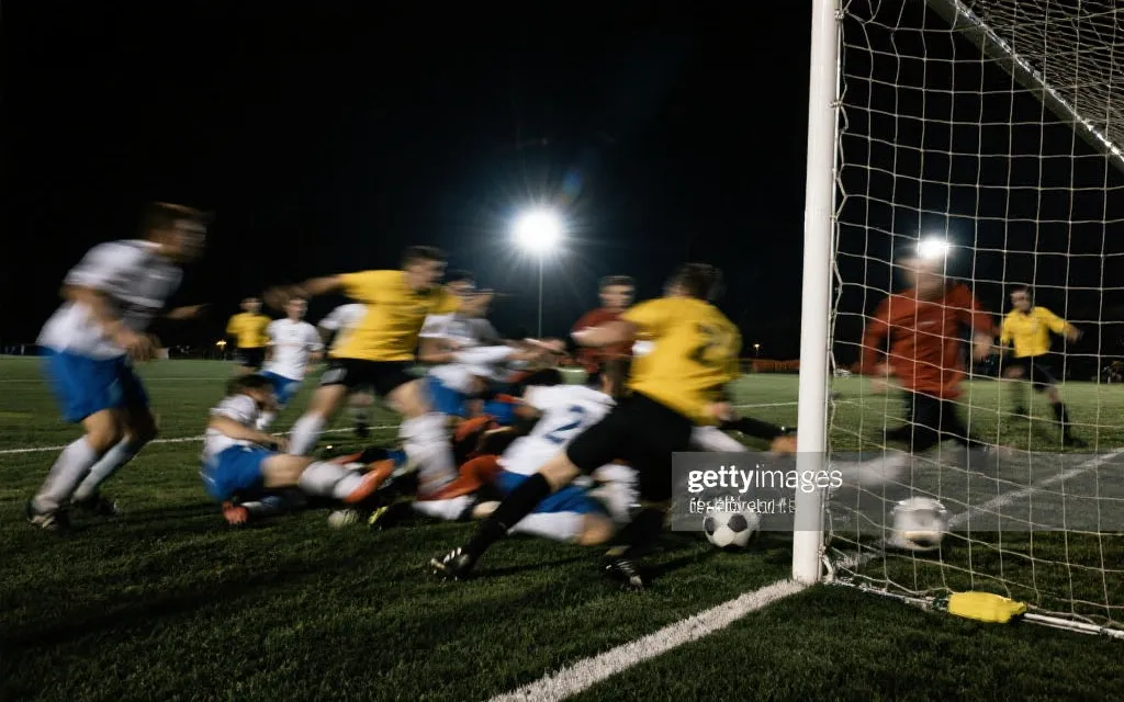 决赛关键进球瞬间的禁区混战与射门，聚光灯、颗粒感、纪录片风格